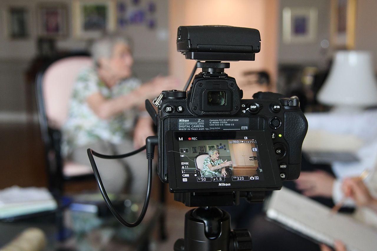 Shot of a video camera screen recording Rose Lipszyc speaking.